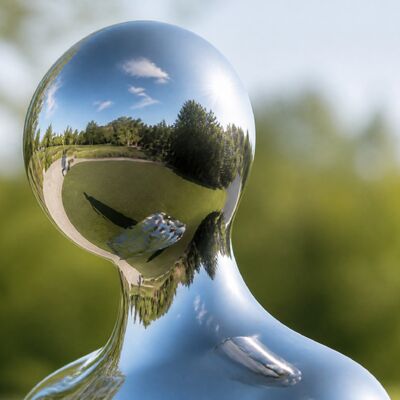 Figure contemporaine en acier inoxydable poli en miroir sur mesure dans un manteau fluide